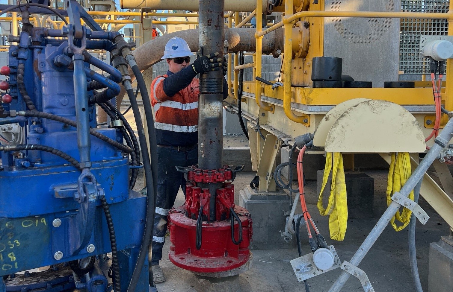 Allegiant technician making up a casing connection with power tongs on a drill rig